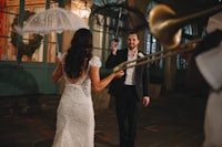 a bride and groom holding an umbrella at a wedding in new orleans