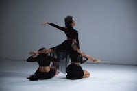 a group of dancers posing in a white studio
