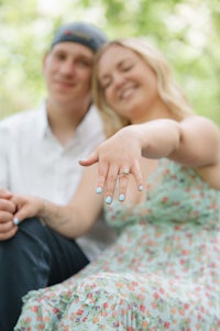 a man and woman are posing for a photo with their engagement ring