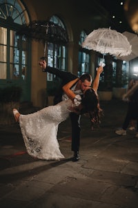 a bride and groom kissing under an umbrella in new orleans