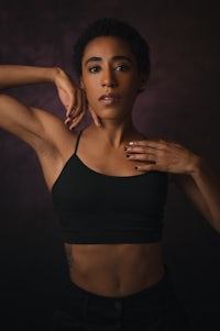 a woman in a black top posing with her hands on her hips