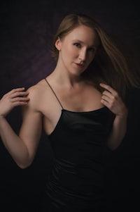 a woman in a black dress posing for a photo
